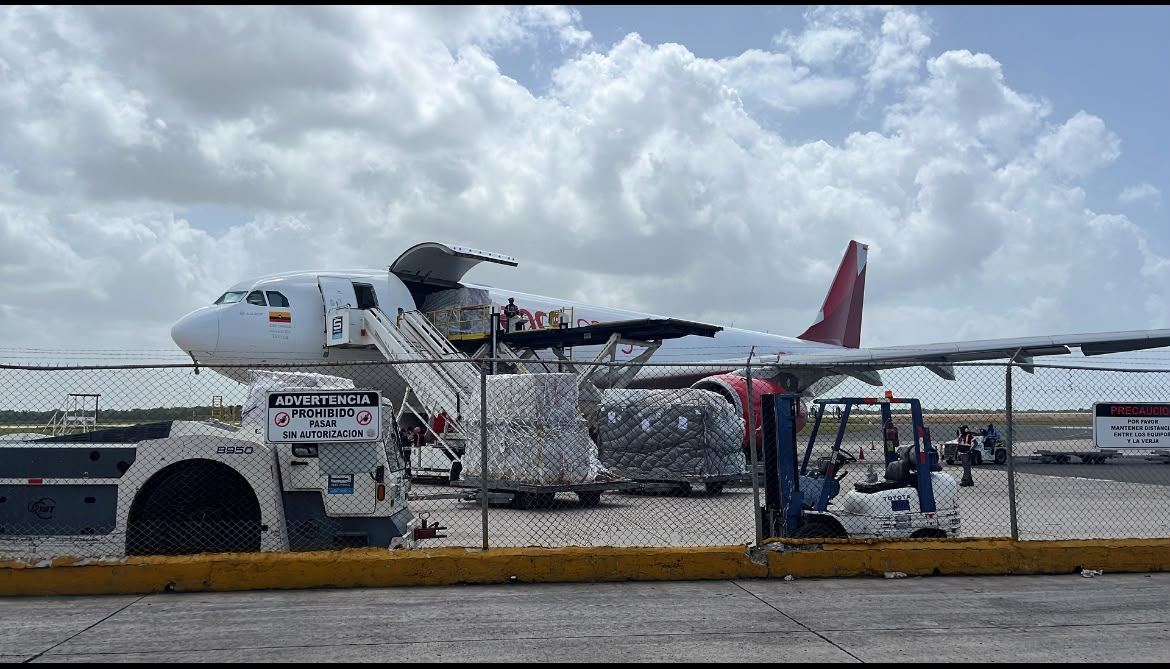 Carga aérea siendo embarcada en avión de carga en pista de aeropuerto